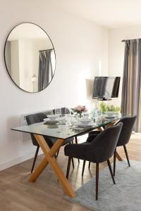 a dining room with a table with chairs and a mirror at Modern, comfy 2 bedroom flat in Hatfield town centre in Hatfield