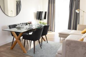 a dining room with a table and chairs and a couch at Modern, comfy 2 bedroom flat in Hatfield town centre in Hatfield