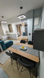 Habitación con mesa, sillas y sala de estar. en Apartmani Park, en Novi Pazar