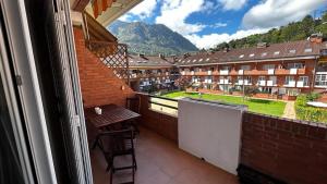 balcón con mesa y vistas a un edificio en Vivienda Falda del Monsacro en Santa Eulalia de Morcín