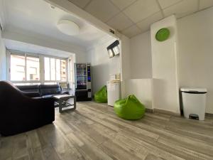 uma sala de estar com um sofá e um repousa-pés verde em LÀtic Rooms em Alicante