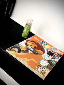 a magazine sitting on a table next to a bottle at Appartement duplex à Chantilly centre in Chantilly