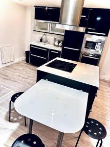 uma cozinha com um fogão e uma bancada branca em Appartement duplex à Chantilly centre em Chantilly