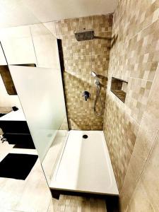 uma casa de banho com um chuveiro e uma banheira branca em Appartement duplex à Chantilly centre em Chantilly