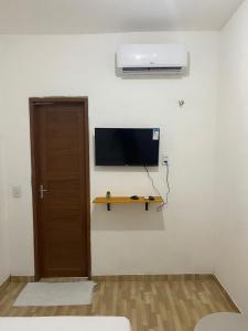 Zimmer mit einem Flachbild-TV an der Wand in der Unterkunft Pousada manu in Trairi