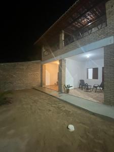 a large brick house with a patio at night at Pousada manu in Trairi
