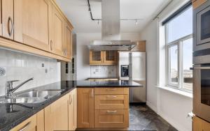 a kitchen with wooden cabinets and a sink at Historical villa in the city center in Tromsø