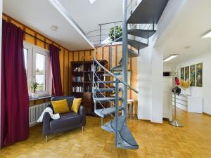 a living room with a spiral staircase and a couch at große, elegante Ferienwohnung in Langenfeld