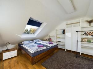 a attic bedroom with a bed and a window at große, elegante Ferienwohnung in Langenfeld