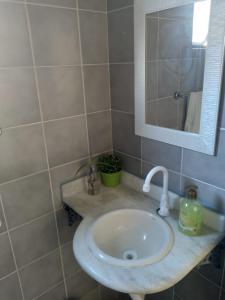 W łazience znajduje się umywalka i lustro. w obiekcie Apartamento em Guarujá Praia do Tombo, 300mts do mar - TOMBO BEACH HOST w mieście Guarujá