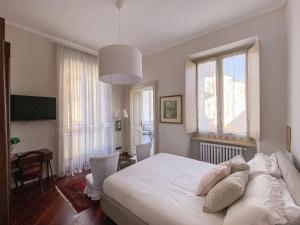 a bedroom with a white bed and a large window at L'Angolo di Casa Verrua in Turin