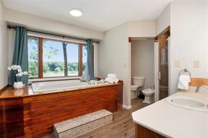 a large bathroom with a large tub and a toilet at Smitten in da Mitten - 18 acres, Arcades, High Spd Web, Hot Tub, Pond! in Berrien Springs
