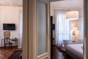 uma sala com um quarto com uma cama e um espelho em L'Angolo di Casa Verrua em Turim