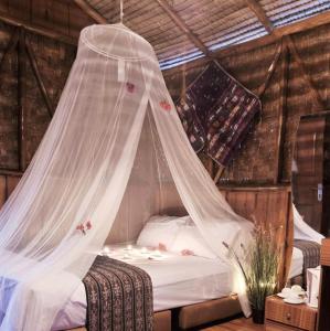 1 cama con mosquitera en una habitación en Bintan Brzee Beach in Bintan Island - Bungalow 1, en Berakit