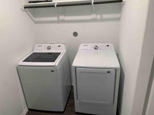 een keuken met een fornuis, een wasmachine en een droger bij 4Bed 2Bath Entire Home 