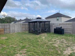 a black gazebo in a yard next to a fence at 4Bed 2Bath Entire Home 