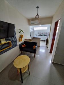 a living room with a black couch and a table at Ohana's Flat Maresias in São Sebastião