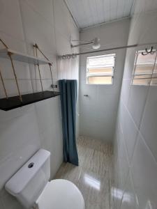 a small bathroom with a toilet and a shower at Ohana's Flat Maresias in São Sebastião