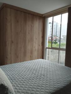 a bedroom with a bed and a large window at Cozy Apartment in Pinares de San Martin. ¡PEREIRA! in Pereira