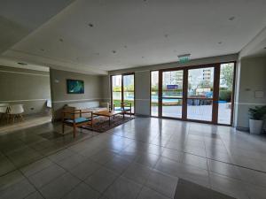 un vestíbulo vacío con una mesa y una gran puerta de cristal en Oceana Suites Marina Del Sol en La Serena
