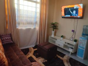 a living room with a couch and a tv at Mahnoor Airbnb Mombasa in Mombasa
