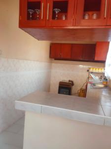 a kitchen with red cabinets and a counter top at Mahnoor Airbnb Mombasa in Mombasa