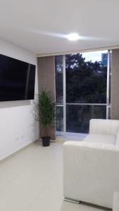 a white living room with a white couch and a large window at Cozy Apartment in Pinares de San Martin. ¡PEREIRA! in Pereira