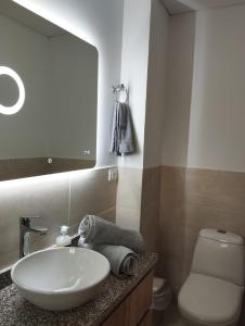 a bathroom with a sink and a toilet and a mirror at Cozy Apartment in Pinares de San Martin. ¡PEREIRA! in Pereira