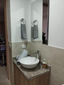 a bathroom with a white sink and a mirror at Cozy Apartment in Pinares de San Martin. ¡PEREIRA! in Pereira