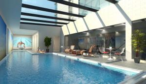 a swimming pool with two people sitting on the edge of it at QV Comfortable Downtown Apartment - 1136 in Auckland