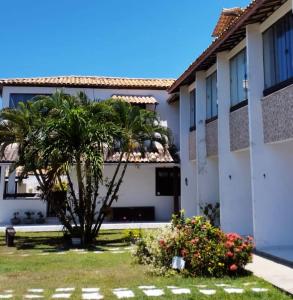 ein Gebäude mit einer Palme davor in der Unterkunft Village Shalom Casa 6 - Porto de Sauipe in Porto de Sauipe