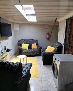 a living room with couches and a flat screen tv at GLOBAL PRIDE in Soweto
