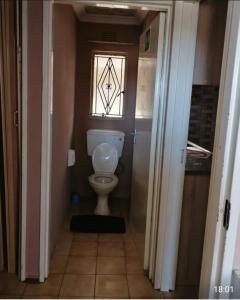 a small bathroom with a toilet and a window at GLOBAL PRIDE in Soweto
