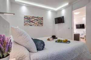 a bedroom with a white bed with a tray on it at Precioso apartamento en el centro de Las Américas a 100 metros de la playa in Playa de las Americas +8 photos