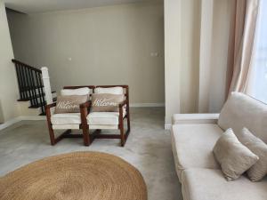 a living room with two chairs and a couch at Graystone at Oyster Bay in Dar es Salaam