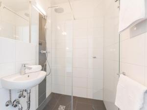 uma casa de banho branca com um lavatório e um chuveiro em Emma Top 4 em Dienten am Hochkönig