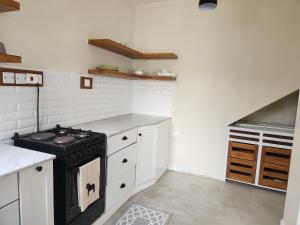 a kitchen with a black stove and white cabinets at Graystone at Oyster Bay in Dar es Salaam