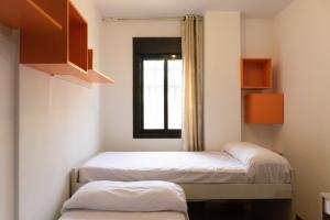 um pequeno quarto com 2 camas e uma janela em AL 2 hab BR 2 baños 6 pax em Madri