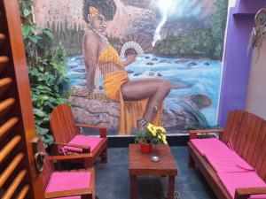 um quarto com cadeiras e um mural de uma mulher em Elisa Posada Hotel em Córdova