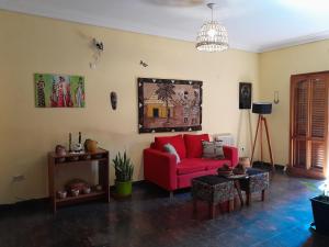 a living room with a red couch and a table at Elisa Posada Hotel in Córdoba