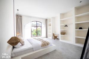 a white bedroom with a bed and a window at Beach Villas Canggu 300m from Echo Beach in Canggu +40 photos