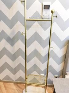 un toallero de oro en una habitación con una pared geométrica en G23新宿最中心 東新宿站5分-Shinjuku center 5 mins to Station, Max 3P 新宿 涉谷 表参道 池袋 上野 代代木 银座 原宿, en Tokio