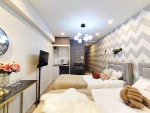 Un dormitorio con dos camas y un televisor. en G23新宿最中心 東新宿站5分-Shinjuku center 5 mins to Station, Max 3P 新宿 涉谷 表参道 池袋 上野 代代木 银座 原宿, en Tokio