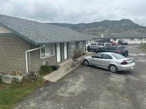 a car parked in a parking lot next to a house at Road Runner Motel Merritt BC in Merritt