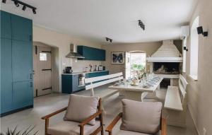 une cuisine avec des armoires bleues, une table et des chaises dans l'établissement Casa Amalia, à Višnjan