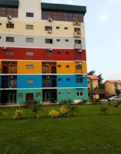 un bâtiment avec des portes et des fenêtres colorées dans un parc dans l'établissement Ibadan Serviced Apartments, à Ibadan