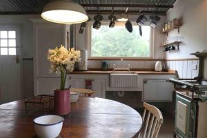 een keuken met een tafel met een vaas met bloemen erop bij The Pottery Shed in Boambee