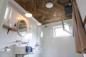 uma casa de banho com um lavatório e um espelho em The Pottery Shed em Boambee