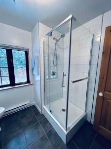 un bagno con doccia con porta in vetro di Chalet Rustique CRDS Tremblant a Lac-Superieur Altre 26 foto