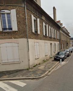 a row of cars parked on a street next to a building at Golden House in Dreux